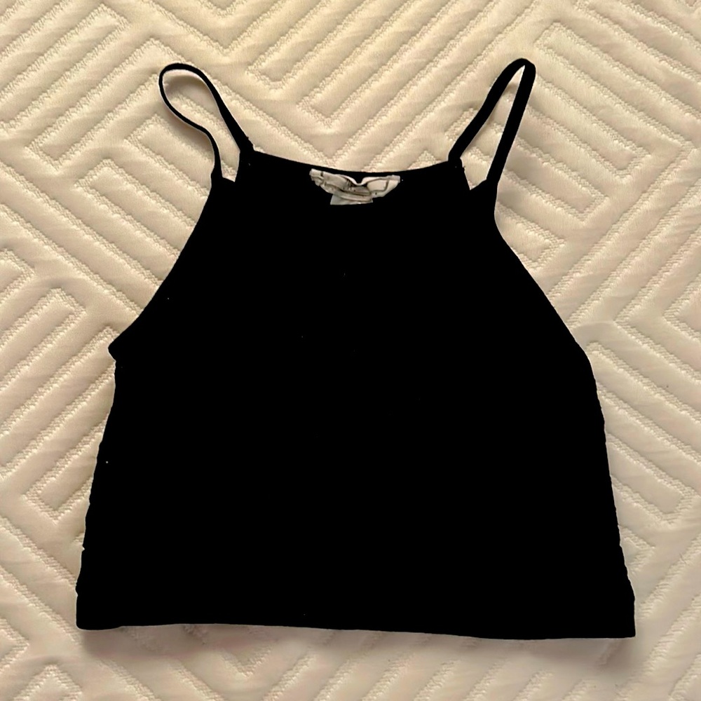 A cropped black shirt with a black flower design and spaghetti straps